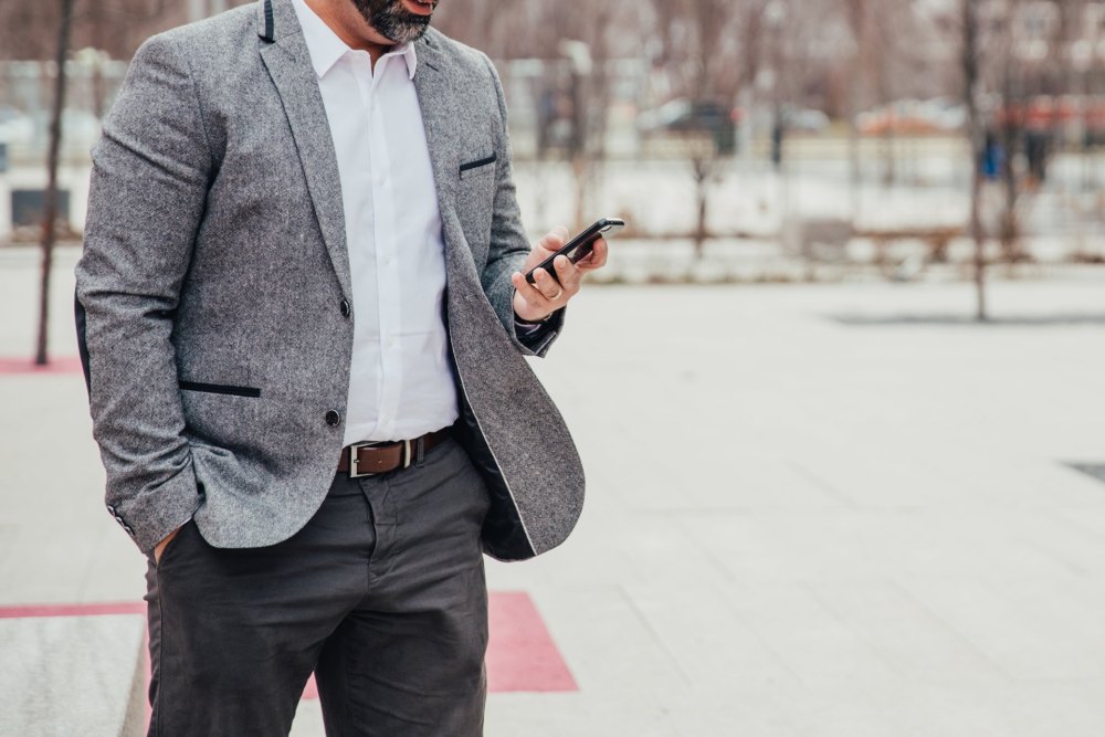 A professional reviewing documents and checking his phone